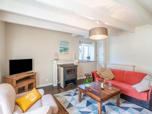 - un salon avec un canapé rouge et une cheminée dans l'établissement Holiday Home Ti ar Stang by Interhome, à Esquibien