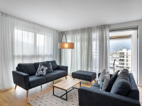 een woonkamer met twee banken en een tafel bij Apartment LocTowers A4-8-2 by Interhome in Locarno