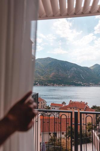 a person looking out of a window at the water at Boutique Hotel Casa del Mare - Vizura in Kotor
