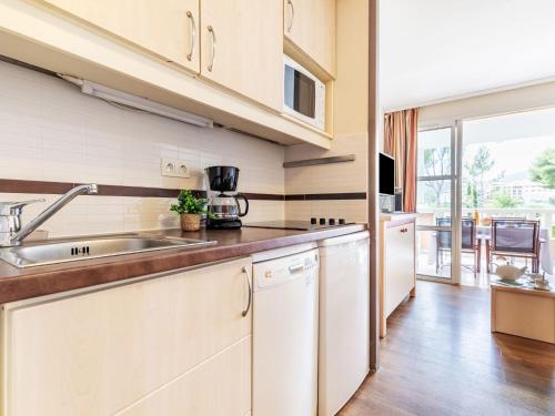 une cuisine avec des armoires blanches et un évier dans l'établissement Studio Le Belvédère - R4 125 by Interhome, à Agay