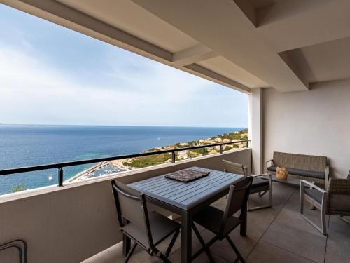 a balcony with a table and chairs and a view of the ocean at Apartment La Spelunca by Interhome in Cargèse