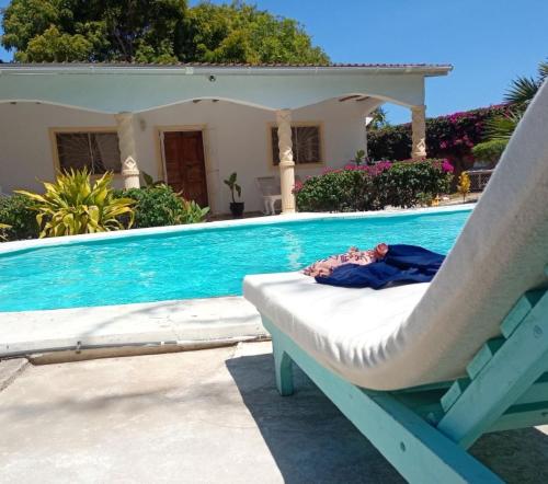 a chair sitting next to a swimming pool at 2 Bedroom Mangrove Cottage with Private Pool in Watamu
