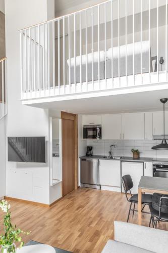 an open kitchen and dining room with white cabinets at The More Hotel Västra Hamnen in Malmö