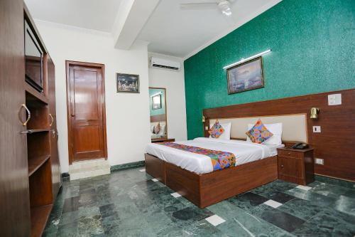 um quarto com uma cama e uma parede verde em FabExpress Primero I em Gurgaon