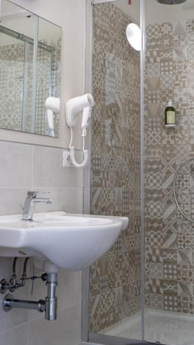 a bathroom with a sink and a shower at Piccolo Catalunya Hostel in Alghero