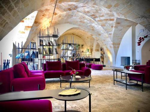 a living room with purple couches and tables at Masseria Li Reni in Manduria