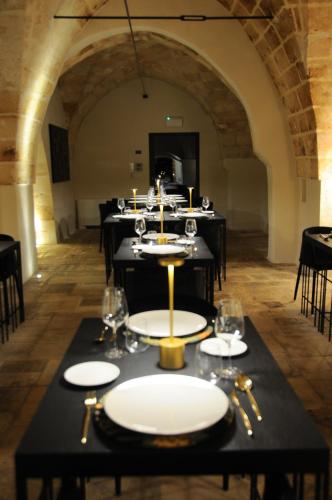 a dining room with black tables with plates and glasses at Masseria Li Reni in Manduria