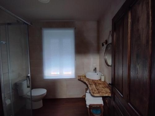 baño con lavabo y aseo y ventana en CASA RURAL VEGASAN en Santa Colomba de la Vega