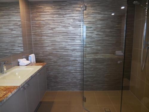 a bathroom with a glass shower and a sink at 2nd Avenue Beachside Apartments in Gold Coast