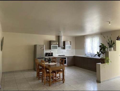 a kitchen with a table and chairs and a refrigerator at Au pied de Lascaux in Montignac