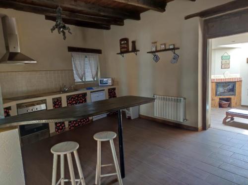 a kitchen with a counter and stools in a room at CASA RURAL VEGASAN in Santa Colomba de la Vega