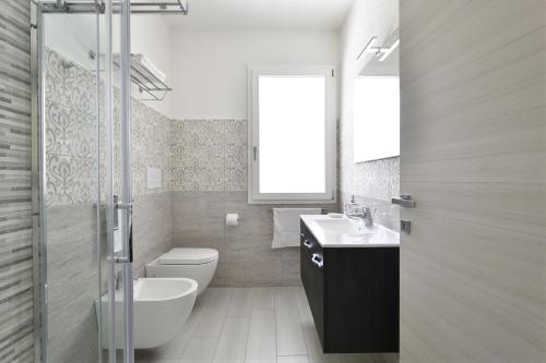 a bathroom with a toilet and a sink and a shower at Venere in Cala Gonone