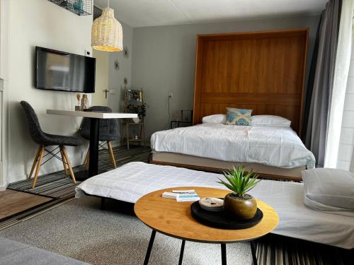 een woonkamer met 2 bedden en een tafel bij Texelheerlijk 10 in De Koog