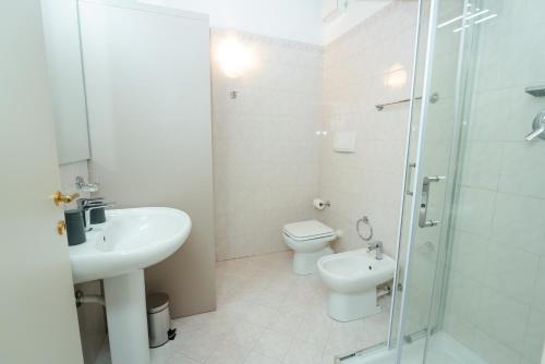 W łazience znajduje się umywalka, toaleta i prysznic. w obiekcie Appartamento La Piazzetta w mieście Carpi