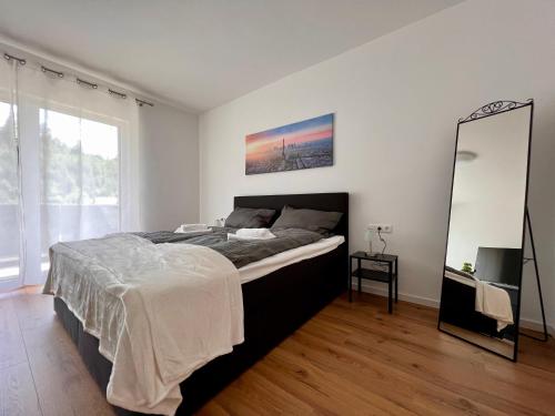 a bedroom with a large bed and a mirror at Idyllische Ferienwohnung mit Balkon & Ausblick in Arzbach