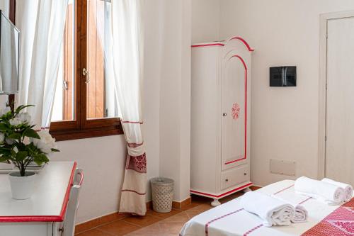 a white room with a bed and a dresser at Hotel Trinità dei Corsari in Torre Dei Corsari