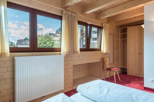 a room with two beds and a window at Hotel Residence Gardena Saslong in Santa Cristina in Val Gardena