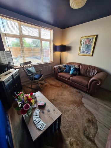 a living room with a couch and a table at Rumer Hill House a unique boutique styled place to stay in Cannock close to A5 the McArthur Glen outlet in Great Wyrley