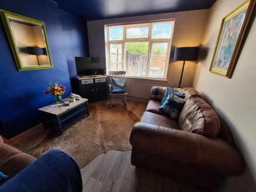 a living room with a couch and a desk at Rumer Hill House a unique boutique styled place to stay in Cannock close to A5 the McArthur Glen outlet in Great Wyrley