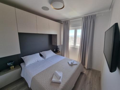 a bedroom with a bed with two white towels on it at Villa Madison in Posedarje