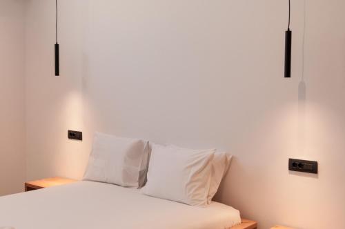 a bedroom with a bed with white sheets and pillows at Stremma Naxos in Aliko Beach