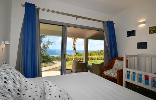 1 dormitorio con 1 cama y puerta corredera de cristal en Zi Limon, en Rodrigues Island