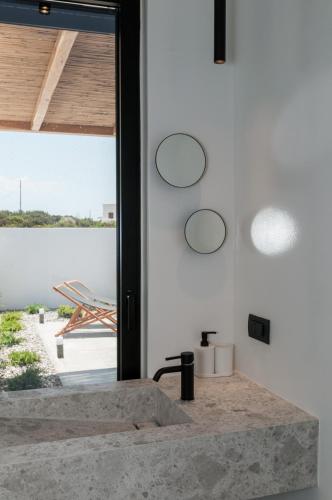 a bathroom with a stone sink in front of a window at Stremma Naxos in Aliko Beach