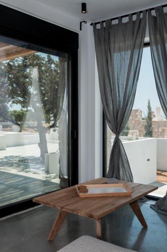 a wooden table in a room with a large window at Stremma Naxos in Aliko Beach