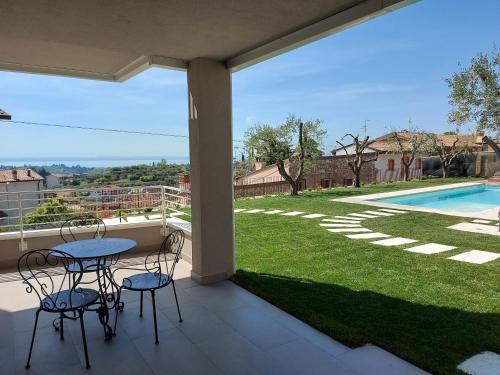 a patio with a table and chairs and a pool at Il cantuccio sul Garda - Relais di charme in Cavaion Veronese