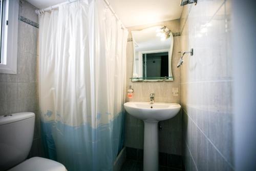 Andros Maisonettes في أجيوس بيتروس: حمام مع حوض ومرحاض ومرآة