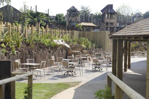 a patio with tables and chairs and a fence at Chessington Resort Hotel in Chessington