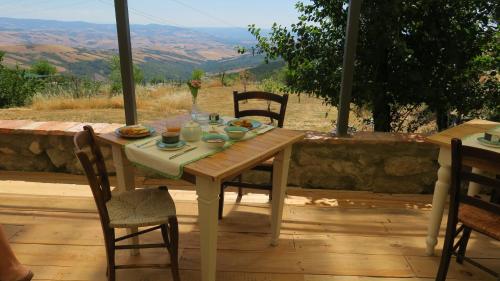 a wooden table and chairs on a patio with a view at CASTAGNA DULCIS in Abbadia San Salvatore