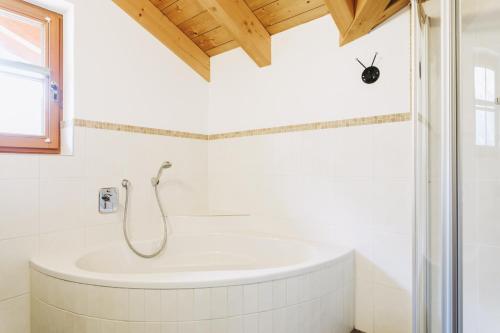 a white bathroom with a tub and a window at Andis Almdorf in Sölden
