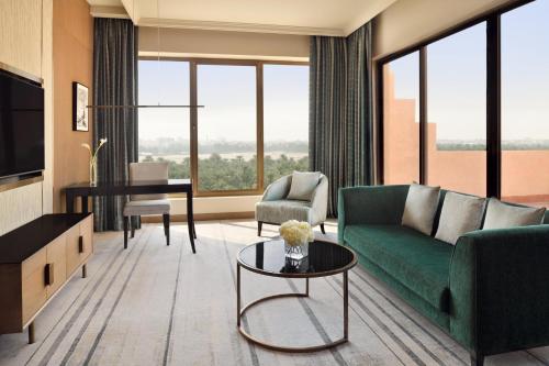 a living room with a green couch and a table at Al Ahsa InterContinental by IHG in Al Ahsa