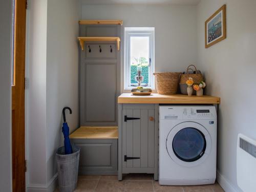 a laundry room with a washing machine and a window at Climbing Rose Cottage - Dog Friendly - Peaceful Cotswold Cottage in Adlestrop
