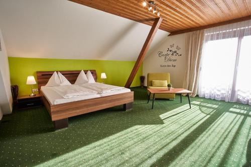 a bedroom with a large bed and a table at Haus am See Stubenberg in Buchberg bei Herberstein