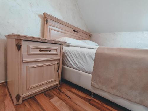 a bedroom with a bed and a wooden cabinet at Motel Almy in Zenica