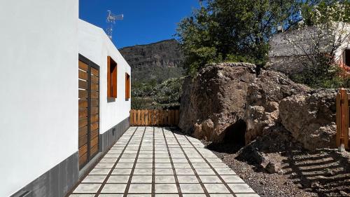 a stone walkway next to a building with a fence at Calma Suites Tejeda in Tejeda