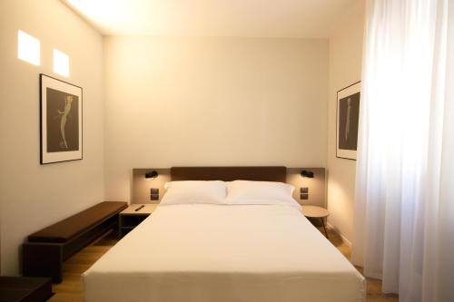 a bedroom with a large white bed and a window at Palazzo Bellocchi - Suites & Apartments in Brindisi