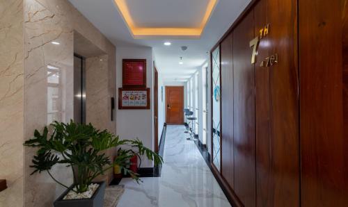a hallway with potted plants in a building at Vương Quốc 3 Hotel in Quy Nhon