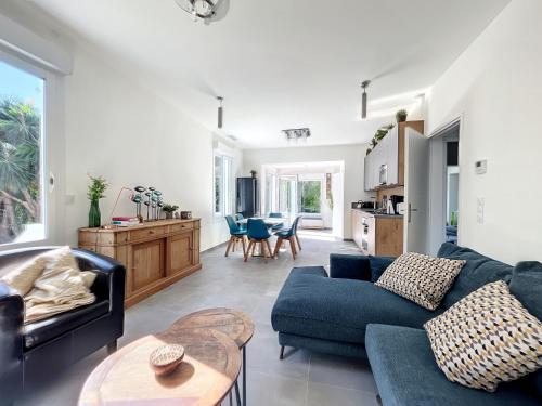 un salon avec un canapé bleu et une table dans l'établissement VILLA VALENTINA BORD DE MER AU CALME, à Antibes