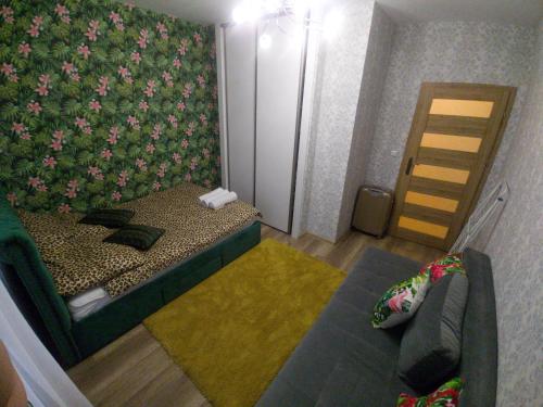 um quarto com uma cama e uma parede com flores em APARTAMENTY WYDMINY em Wydminy