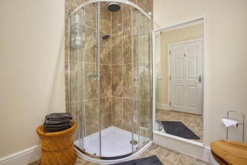 um chuveiro com uma porta de vidro na casa de banho em Old Orchard em Otterford