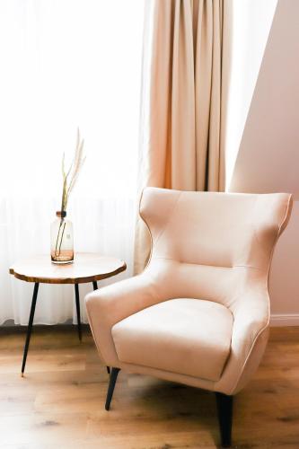 a white chair in a room with a table at Moderne Ferienunterkunft in ruhiger Lage und nur 7 Gehminuten vom Strand entfernt - hoher Schlafkomfort und Gartenzugang für die ideale Erholung an der Ostsee in Scharbeutz