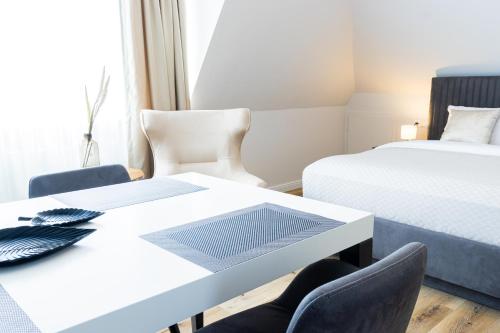 a room with two beds and a table and chairs at Moderne Ferienunterkunft in ruhiger Lage und nur 7 Gehminuten vom Strand entfernt - hoher Schlafkomfort und Gartenzugang für die ideale Erholung an der Ostsee in Scharbeutz