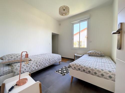 une chambre avec deux lits et une fenêtre dans l'établissement VILLA VALENTINA BORD DE MER AU CALME, à Antibes