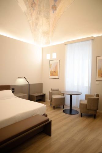 a bedroom with a bed and a table and chairs at Palazzo Bellocchi - Suites & Apartments in Brindisi