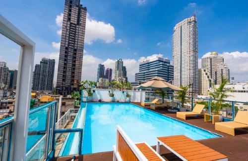 a swimming pool on the roof of a building with a city skyline at Sapphire hotel Silom Bangkok in Bangkok