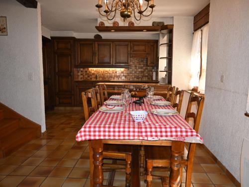 uma mesa de jantar com uma toalha de mesa xadrez vermelha e branca em Chalet Véronique by Interhome em Ovronnaz