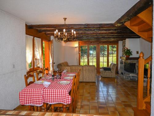 uma sala de jantar com uma mesa com uma toalha de mesa vermelha e branca em Chalet Véronique by Interhome em Ovronnaz